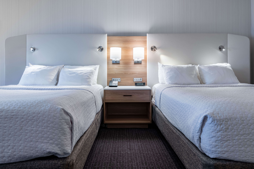 Double queen hotel room with shared nightstand