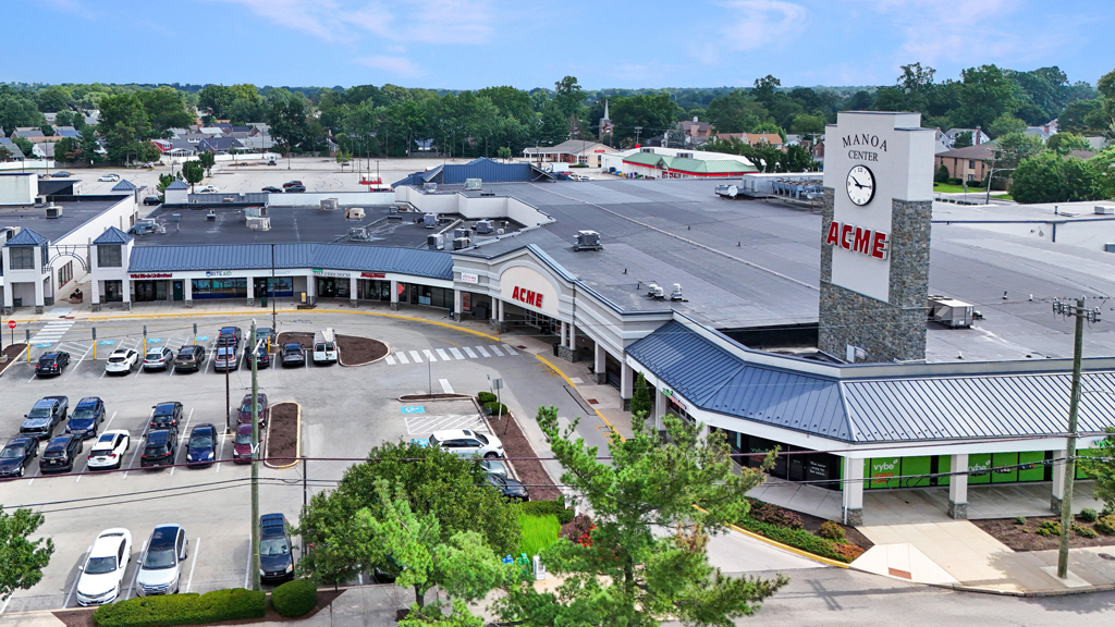 Aerial view of shopping center with parking lot and ACME store