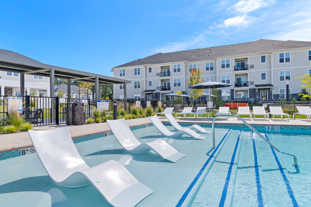 swimming pool with lounge chairs in the water